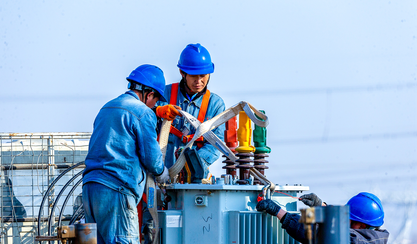 图8为2026年1月8日上午，在河南省安阳市滑县半坡店镇杏头村的农田里，杏头5号机井通电配套工程施工现场，施工队员正在准备起吊变压器。（王亚方 摄）