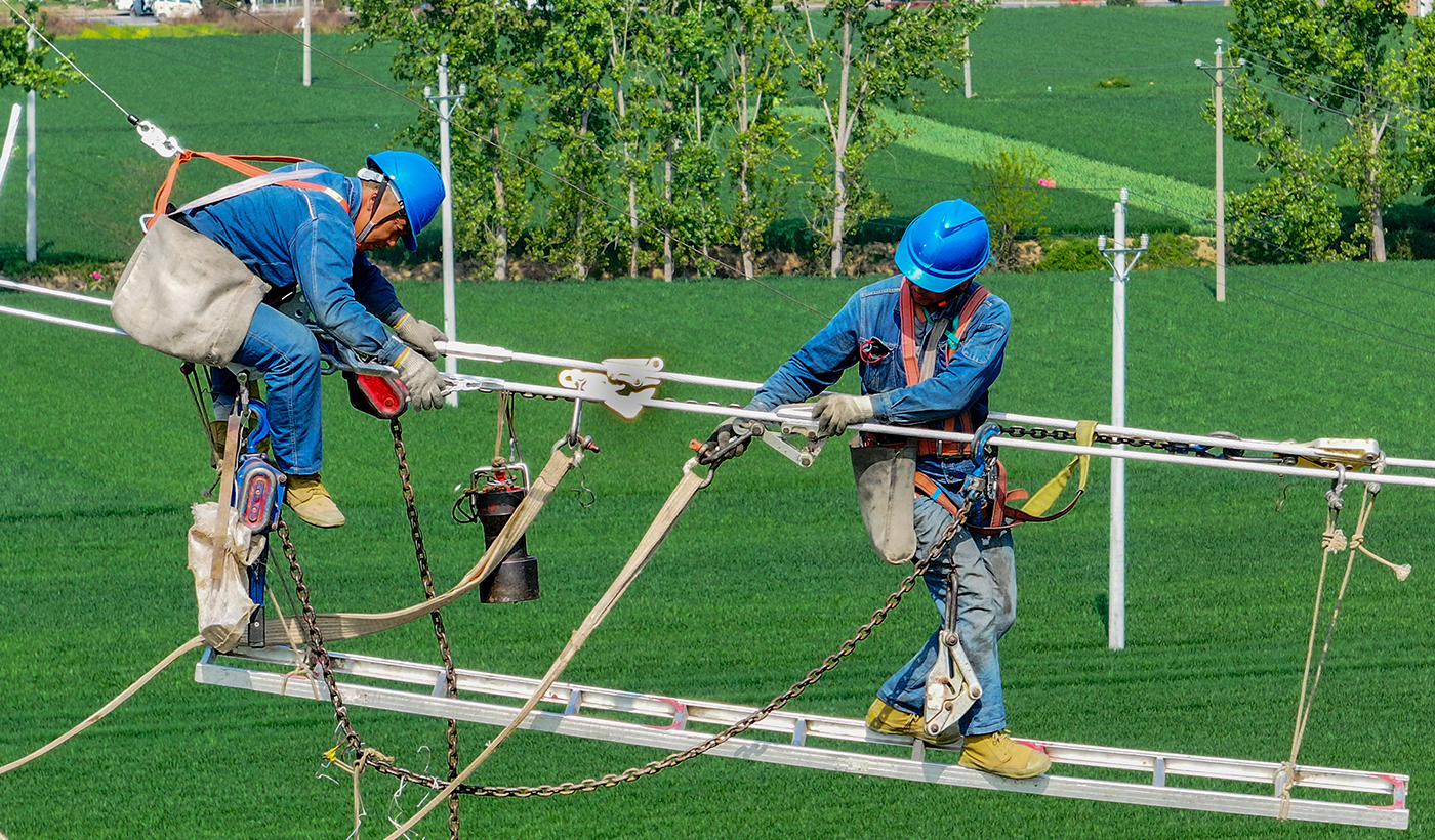 图为：2026年4月16日，在河南省安阳市滑县老店镇小屯村110千伏楚老线路升级改造施工现场，国网滑县供电公司37名电力工人正在加紧施工。（王亚方 摄）